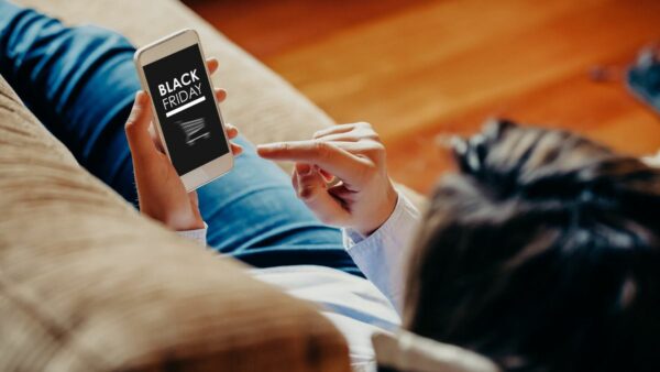 Person shopping on a couch looking at Black Friday 2023 deals.