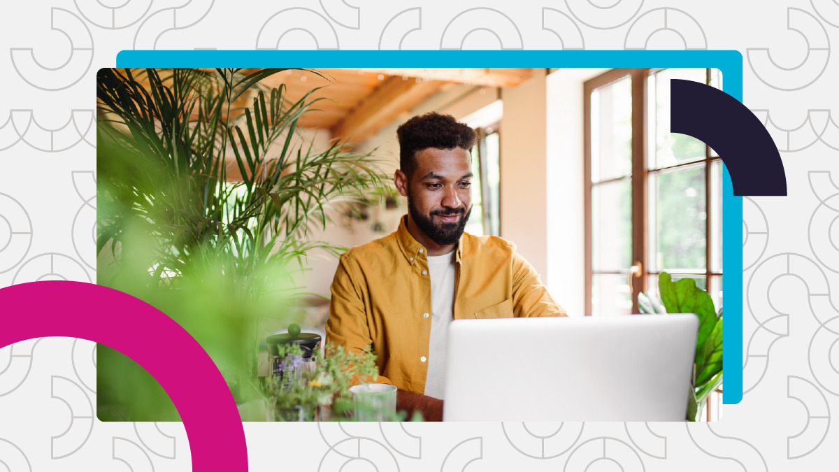 Man works on laptop in bright office with plants